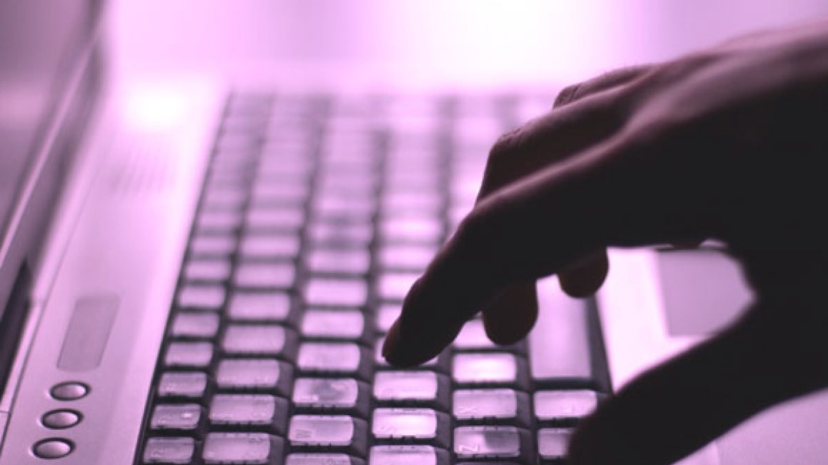 imagem de uma mão digitando em um teclado de um laptop