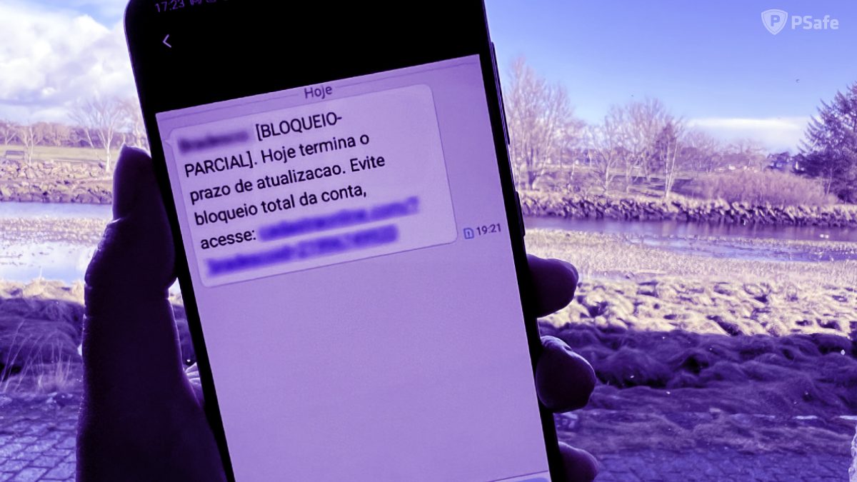 Imagem de um celular com um falso SMS na tela, que está simulando um bloqueio de conta