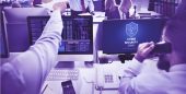 escritório com computadores em tela de notificação de ataque ransomware